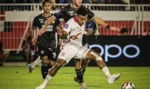 Yakob Sayuri berduel dengan bek semen padang pada laga Semen Padang vs Malut United.