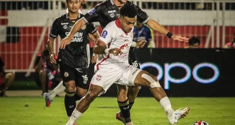 Yakob Sayuri berduel dengan bek semen padang pada laga Semen Padang vs Malut United.