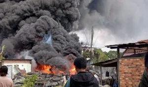 Kepulan asap hitam pekat membumbung tinggi akibat kebakaran ratusan ban bekas di Jalan Prof. Dr. Soepomo, Kemuning, Palembang.