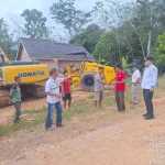 Proses pembersihan lumpur jalan Desa Mekar Jaya Jirak Jaya menggunakan alat berat PUPR.