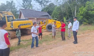 Proses pembersihan lumpur jalan Desa Mekar Jaya Jirak Jaya menggunakan alat berat PUPR.