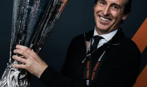 Pelatih Unai Emery tersenyum lebar sambil memegang trofi kemenangan setelah membawa Aston Villa juara kompetisi sepak bola Eropa.