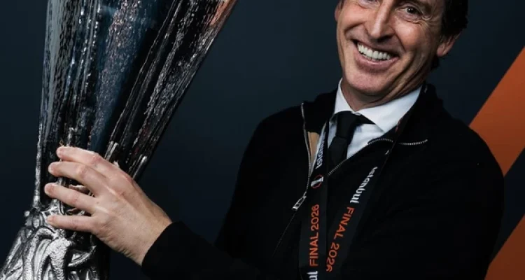 Pelatih Unai Emery tersenyum lebar sambil memegang trofi kemenangan setelah membawa Aston Villa juara kompetisi sepak bola Eropa.