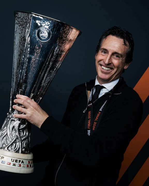 unai-emery-raja-liga-europa-aston-villa Pelatih Unai Emery tersenyum lebar sambil memegang trofi kemenangan setelah membawa Aston Villa juara kompetisi sepak bola Eropa.