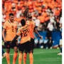 Tiga penggawa Timnas Belanda mengenakan jersey oranye sedang merayakan gol di lapangan. Crysencio Summerville bernomor punggung 24 tampak mengangkat kedua tangan ke atas didampingi rekan setimnya.
