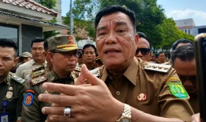 Bupati Muba HM Toha Tohet SH dengan seragam dinas khaki cokelat sedang berbicara memberikan penegasan di depan awak media.