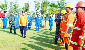 Bupati Muba H M Toha Tohet SH dengan seragam dinas rescue oranye dan topi komando berjalan gagah didampingi perwira TNI AD berseragam loreng melakukan inspeksi barisan pasukan penanggulangan bencana di lapangan rumput hijau Pendopoan Griya Bumi Serasan Sekate