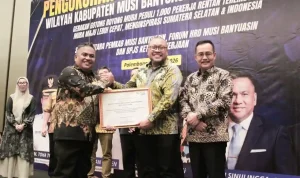 Kepala Disnakertrans Muba Herryandi Sinulingga AP didampingi Wakil Bupati Muba Kiai Abdur Rohman Husen, menjabat tangan Kepala BPJS Ketenagakerjaan Wilayah Sumbagsel Kuncoro Budi Winarno