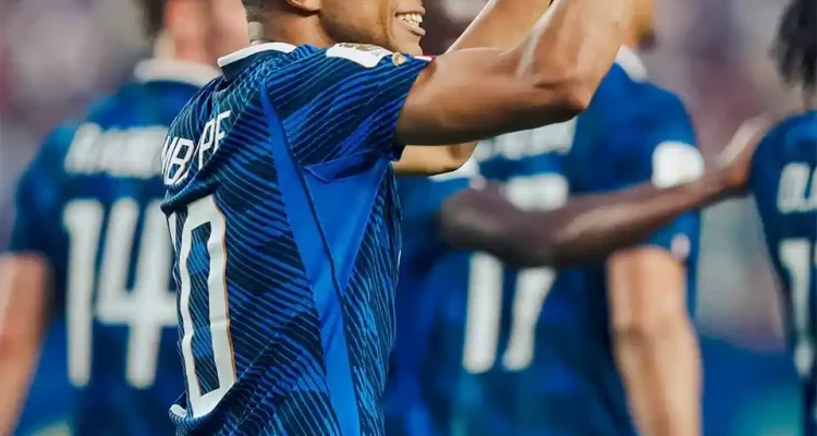 Penyerang Timnas Prancis Kylian Mbappe tersenyum lebar sambil mengepalkan tangan kanannya ke atas merayakan golnya.