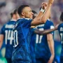Penyerang Timnas Prancis Kylian Mbappe tersenyum lebar sambil mengepalkan tangan kanannya ke atas merayakan golnya.