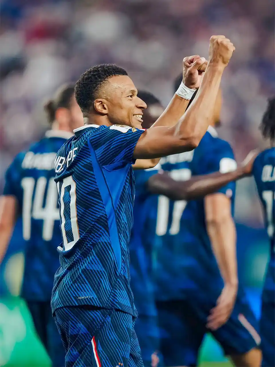 kylian-mbappe-selebrasi-caps-100-piala-dunia Penyerang Timnas Prancis Kylian Mbappe tersenyum lebar sambil mengepalkan tangan kanannya ke atas merayakan golnya.