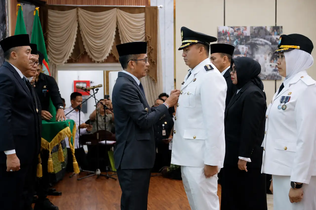 pelantikan-camat-kertapati-palembang-rifandi-putra-2026 Prosesi upacara pelantikan jabatan di lingkungan Pemkot Palembang oleh Walikota H. Ratu Dewa. Tampak Walikota Palembang berbaju jas abu-abu sedang menyematkan pin tanda jabatan di dada kanan seragam dinas upacara putih milik Rifandi Putra, S.STP., M.Si. yang berdiri tegap menghadap pimpinan