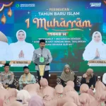 peringatan-1-muharram-1448h-pemkab-muba-wabup-abdur-rohman Wakil Bupati Muba Kyai H Abdur Rohman Husen baju koko abu-abu dan peci hitam berbicara di podium berlogo Pemkab Muba. Di belakangnya terdapat layar LED besar bertuliskan Peringatan Tahun Baru Islam 1 Muharram 1448 H beserta foto pimpinan daerah.