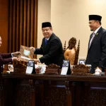 rapat-paripurna-dprd-sumsel-pansus-pad-2026 Penyerahan dokumen laporan hasil kerja Pansus DPRD Sumsel. Tampak Juru Bicara Pansus menyerahkan berkas bersampul batik kepada Wakil Gubernur Sumsel Cik Ujang di meja pimpinan Rapat Paripurna XXXVIII, disaksikan Ketua DPRD Sumsel Andie Dinialdie dan pimpinan dewan lainnya.